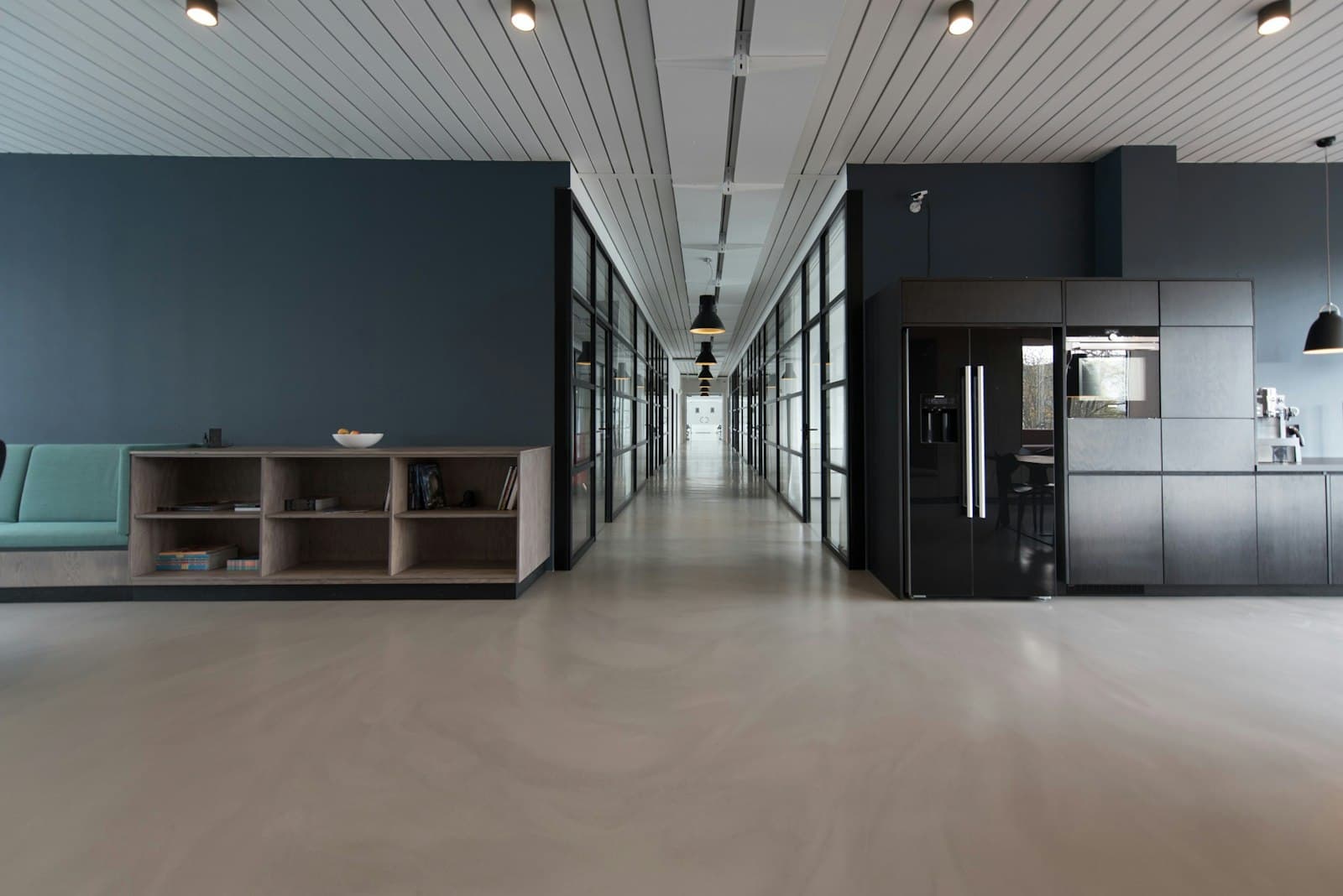 A bright open workspace with long shared desks and greenery